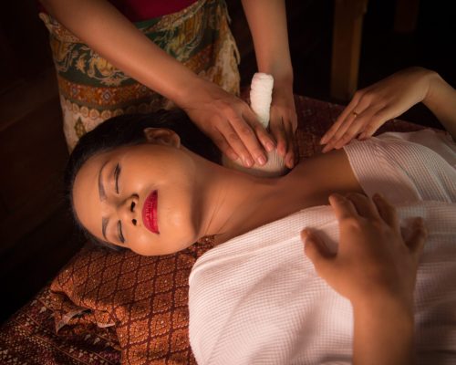 Masseur doing massage on Asian woman body in the spa salon